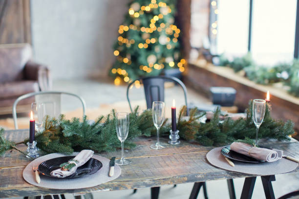 istock Rustic Christmas served table with vintage silverware, candles and fir twigs 906875594