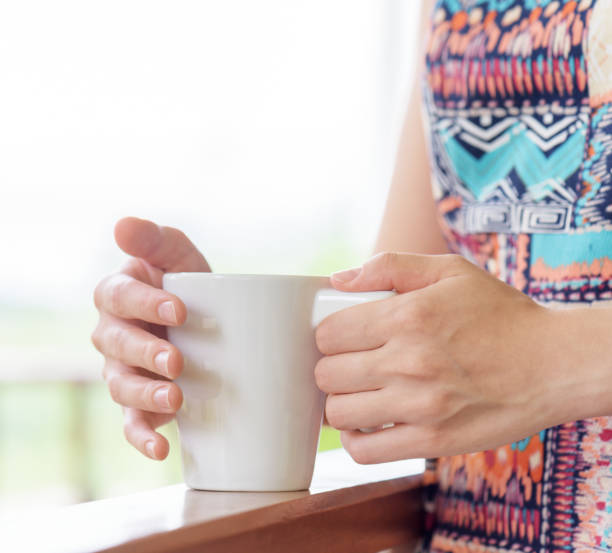 istock Young woman enjoying a mug of beverage. 906875598