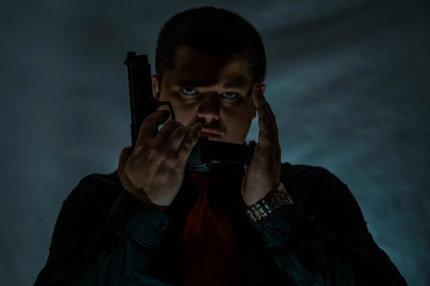 istock A criminal with a gun in his hand. 906882436