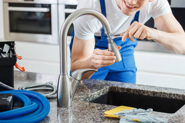 istock Smiling plumber fixing faucet 906883682