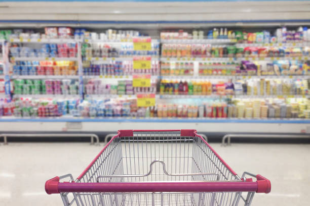 istock Supermarket aisle with empty shopping cart 906895258