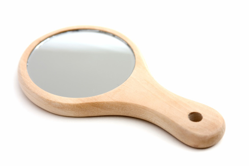 A small handheld mirror with a wooden handle. 