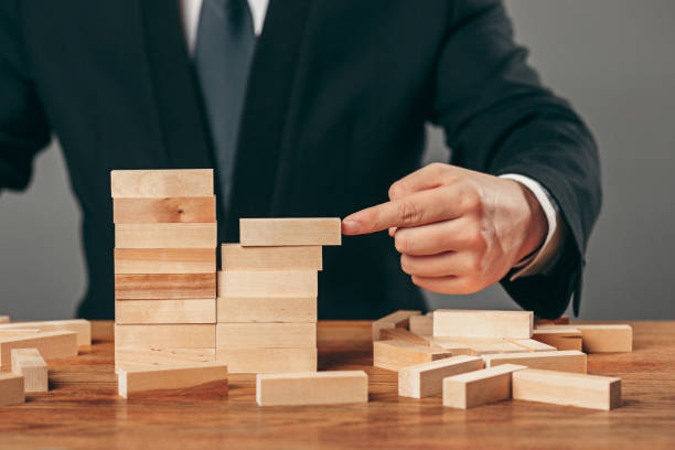 istock Man and wooden cubes on table. Management concept 906909374