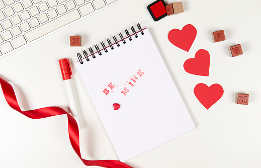 Love note. Keyboard, red hearts, pen etc. Top view.