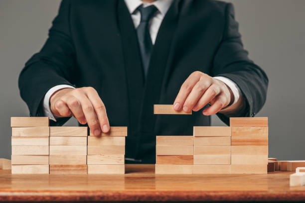 istock Man and wooden cubes on table. Management concept 906930402