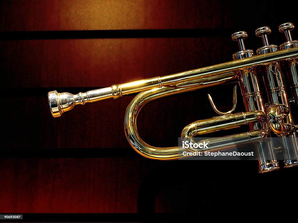 Trumpet Photo of a trumpet with a grained dark wall. Taken in a music store. Brass Stock Photo