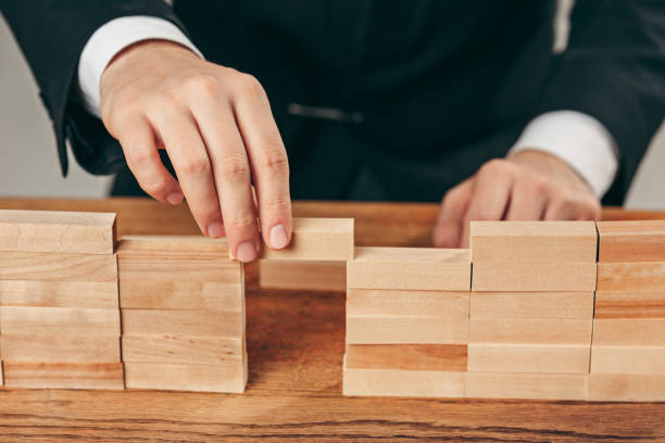 istock Man and wooden cubes on table. Management concept 906937146