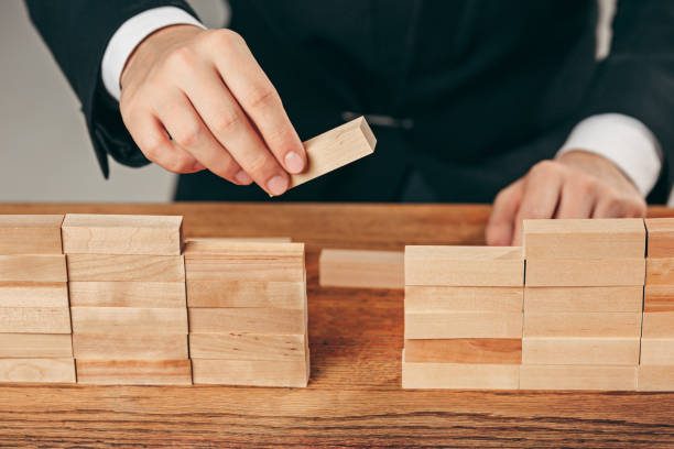 istock Man and wooden cubes on table. Management concept 906941496
