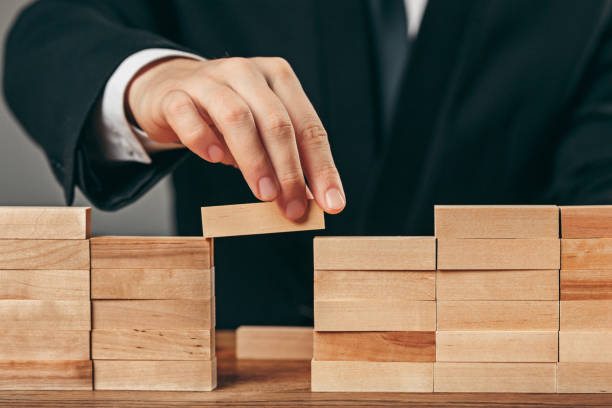 istock Man and wooden cubes on table. Management concept 906946016