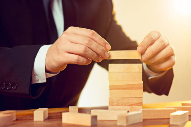 istock Man and wooden cubes on table. Management concept 906950538