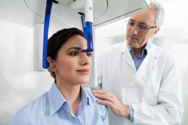 Cтоковое фото Стоматолог, контролирующий свою пациентку перед рентгеновским панорамным цифровым