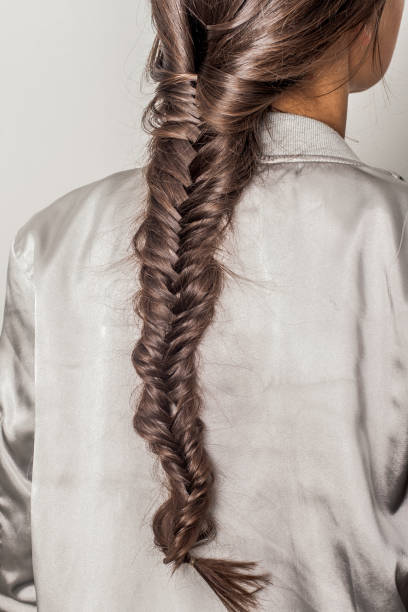 The fine, elegant texture of straight, dark hair is captured in a diagonal flow, creating a sophisticated and minimalist background for beauty and wellness.