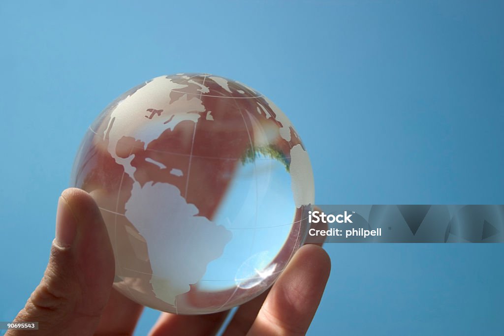 Hand holding globe model on blue background  Globe, World, Earth Market - Retail Space Stock Photo