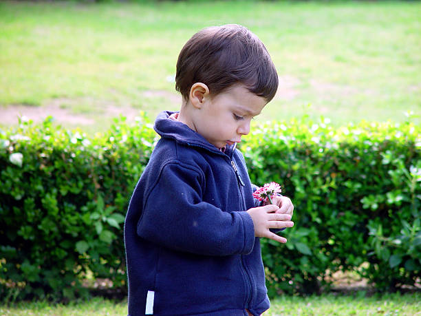 istock Baby Looking at a Flower in his Hand 90696143