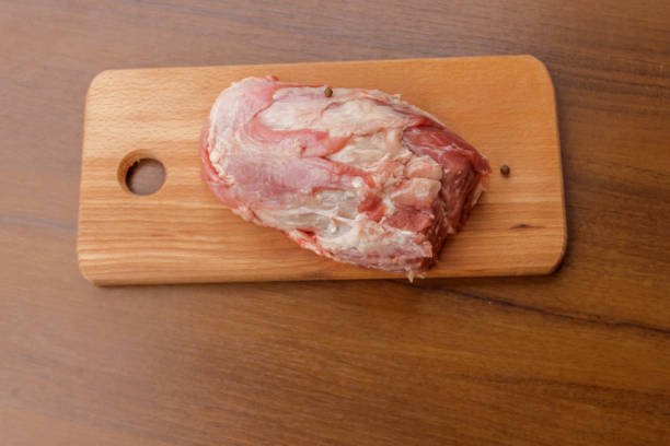 istock Raw pork meat on cutting board on a table. Top view 906962274