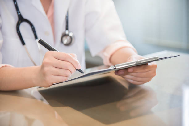 istock female doctor is writing something on clipboard. 906962852