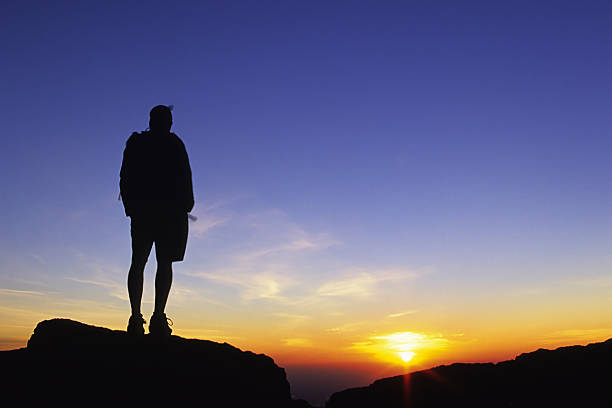 istock silhouetted man watching the sunrise sky 90696537