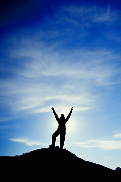 istock silhouette arms raised into sky landscape 90696693