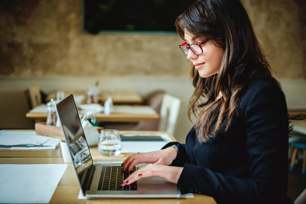 istock Happy girl typing on computer in restaurant 906969466