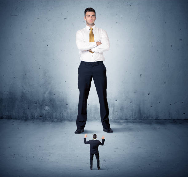istock Angry huge business man lokking at small guy 906985626