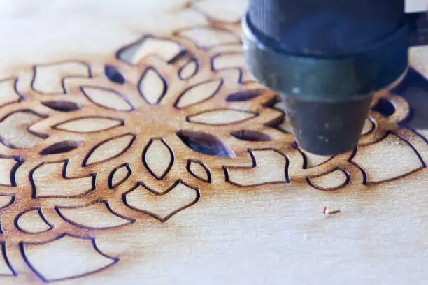 The laser cuts out a tree in the form of a mandala