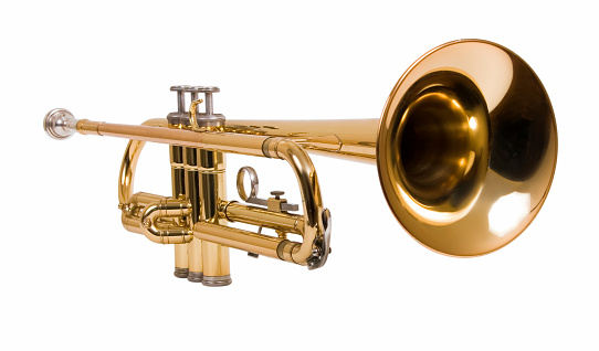 Full length profile shot of a young man walking and playing a trumpet isolated on white background