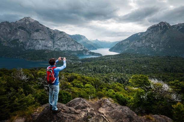 Hiker stands on top of the mountain Hiker stands on top of the mountain and takes picture of the valley with smartphone. Patagonia, Argentina patagonia argentina photos stock pictures, royalty-free photos & images