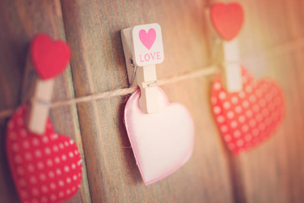 istock Lovely hearts hanging on wooden background. Write your message. 907032390