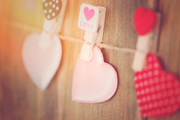 istock Lovely hearts hanging on wooden background. Write your message. 907035520