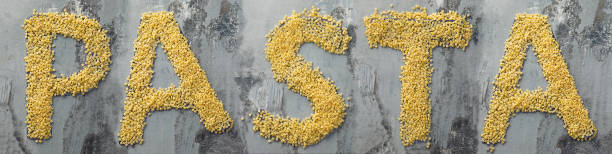 istock Word pasta created from pasta macaroni on the wooden table in the kitchen 907044428