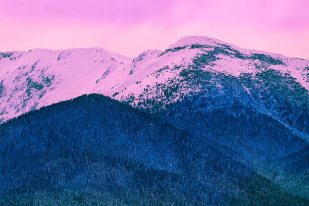istock Beautiful sunset view on the high winter mountains peaks, on the sky background. 907045084