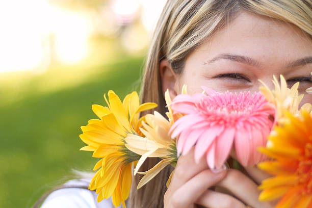 istock Young woman smiling behind colorful flowers 90705592