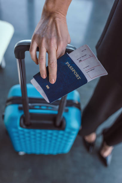 istock woman with suitcase and flight ticket 907065888