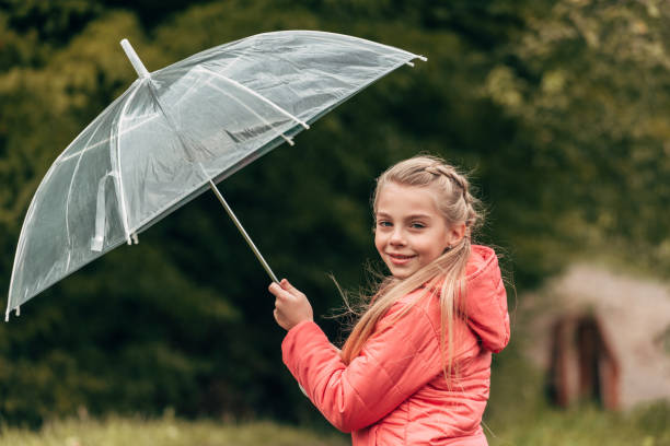 istock child with umbrella in autumn park 907077202