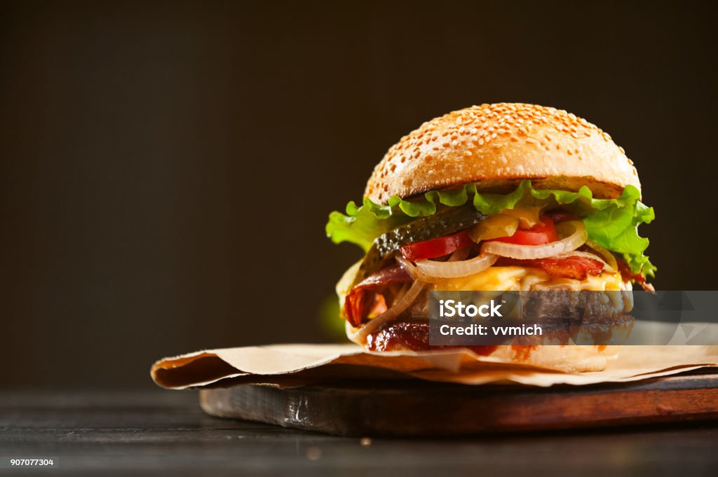 una deliciosa deliciosa hamburguesa casera utilizado para cortar carne en la mesa de madera. - Foto de stock de Hamburguesa de carne libre de derechos