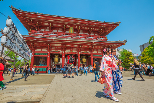 Tokyo, Japan - April 19, 2017: young women in traditional japanese kimonos coming out of the Hozomon, Treasure-House Gate, theentrance of Buddhist Temple Senso-ji, Asakusa, the oldest temple in Tokyo.