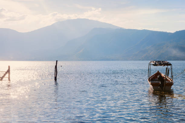 Wooden piers and a boat at lake Yojoa, Honduras
