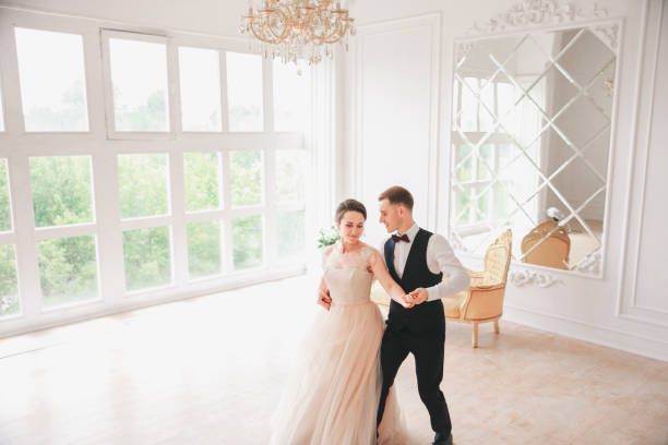 danses de couple première danse au studio de mariage. jour du mariage. heureuse jeune mariée et le marié le jour de leur mariage. couple de mariage - nouvelle famille. - young men young women bride hairstyle photos et images de collection