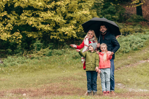 istock family with umbrella in park 907097938