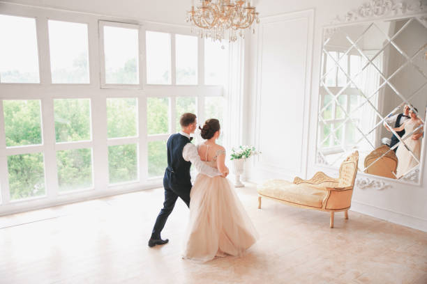 danses de couple première danse au studio de mariage. jour du mariage. heureuse jeune mariée et le marié le jour de leur mariage. couple de mariage - nouvelle famille. - young men young women bride hairstyle photos et images de collection