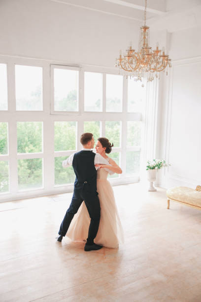 istock wedding couple dances first dance on the studio. Wedding day. Happy young bride and groom on their wedding day. Wedding couple - new family. 907100360
