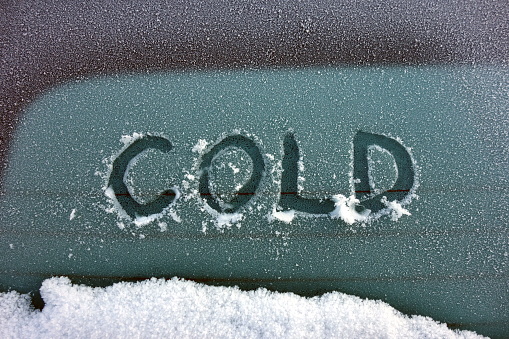 Word cold written on rear glass of a vehicle, severe winter concept