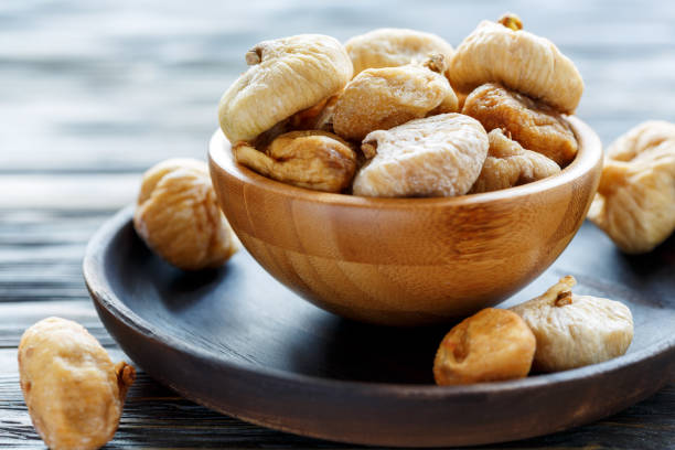istock Sweet dried figs in a wooden bowl. 907136078