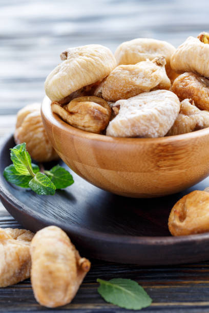 istock Wooden bowl with dried figs. 907137026