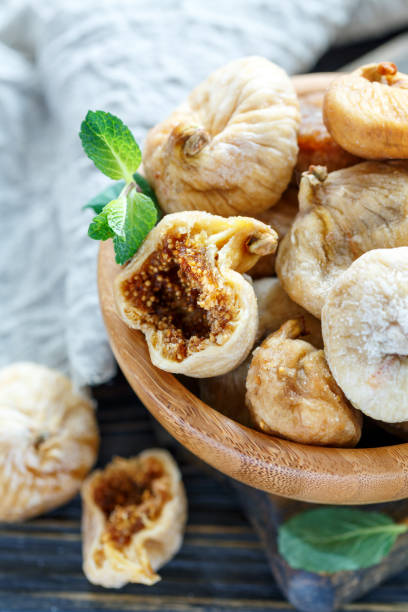 istock Dried figs and mint in a wooden bowl. 907137150