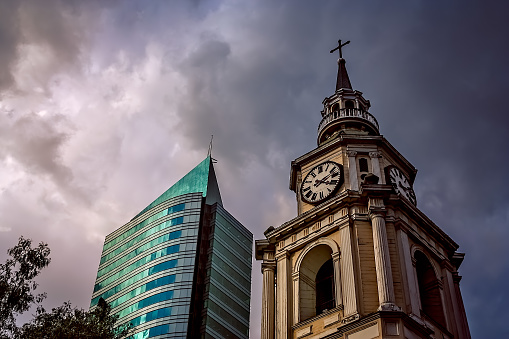 Old church clock tower and modern highrise apartment in Santiago, Chile, South America