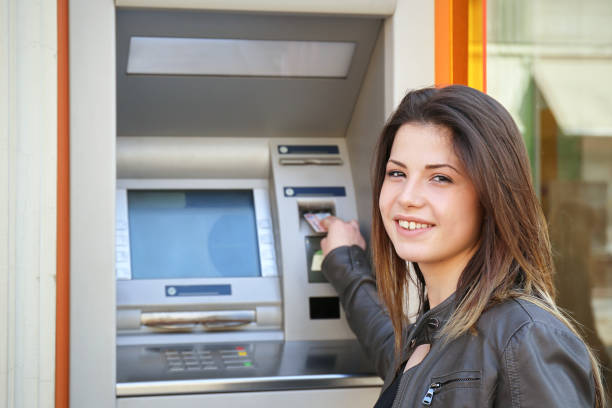 istock young woman insert credit card to atm 907160960