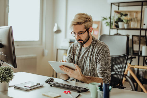 istock Young hipster using his digital tablet in the office during morning hours 907175246