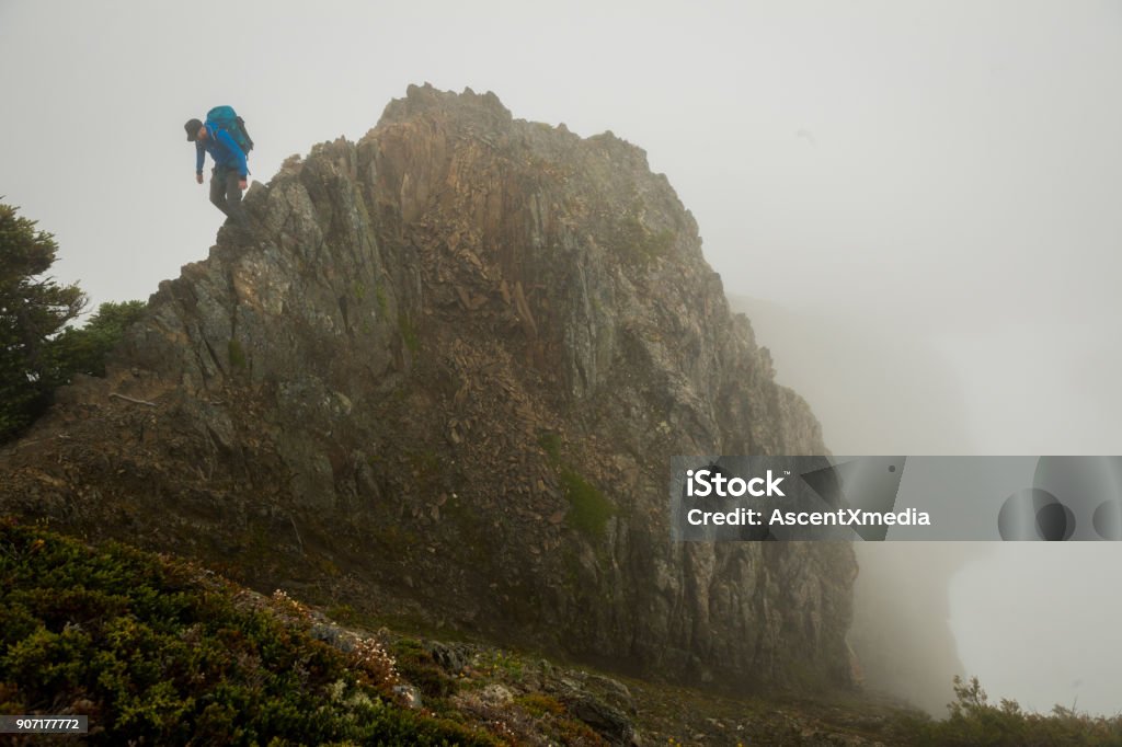 Solo travel Man walking a ridgeline in the fog 30-39 Years Stock Photo