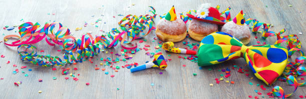 istock Carnival donuts with paper streamers and party bow tie 907182200